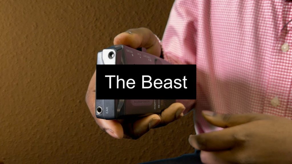 Title card for The Beast showing a man holding a dictaphone